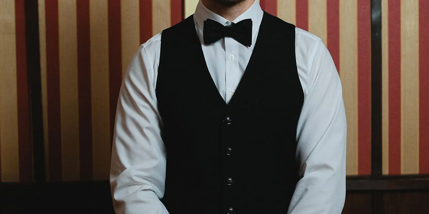 Croupier in gilet nero dietro un tavolo da gioco