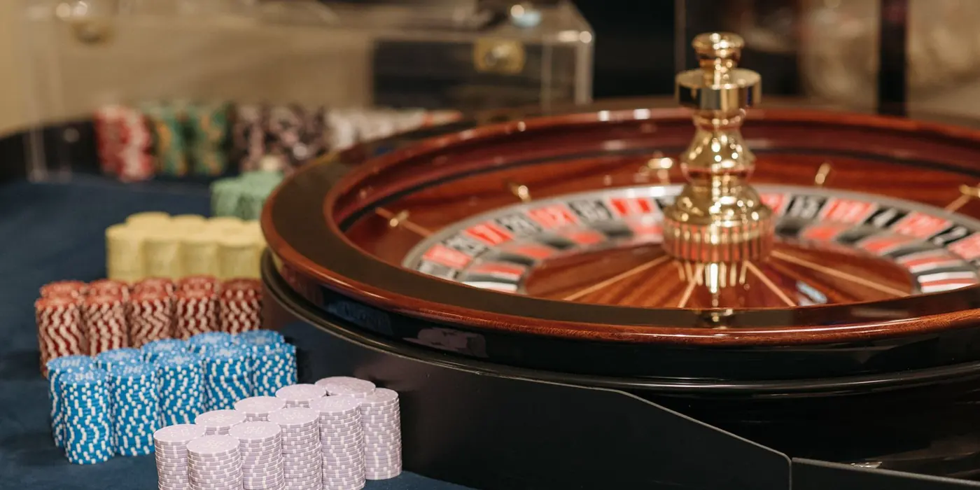 Pile di fiches accanto a una ruota da casinò